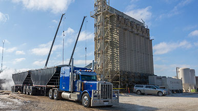 A truck and tower used for transporting and storing sand at a hydraulic fracturing operation