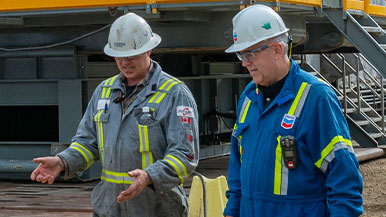 Chevron employee and supplier talking at a drilling site in Alberta