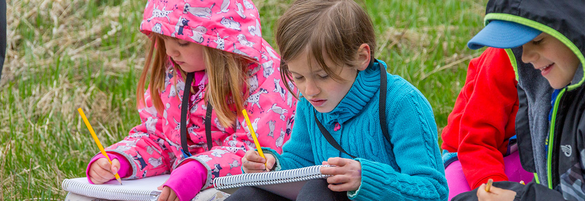 Students using notebooks at the Chevron Open Minds Cross Conservation School