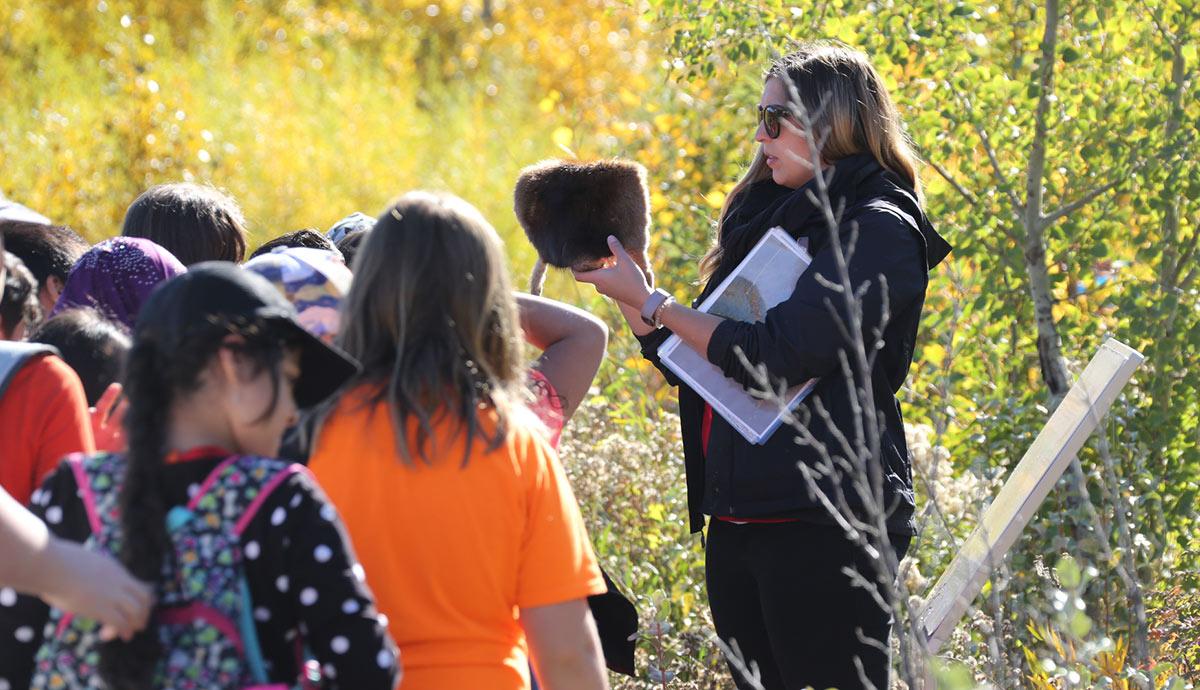 Teacher showing students a muskrat pelt at the Chevron Learning Pathway