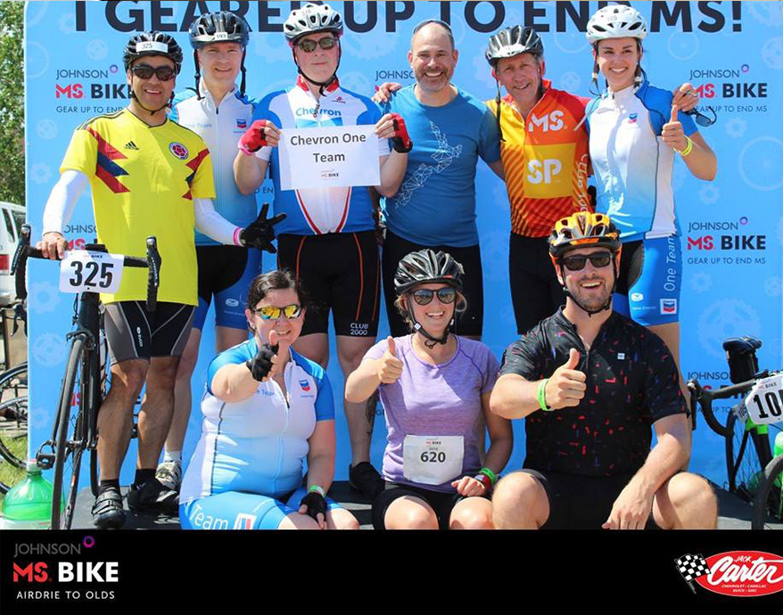 The Chevron One team pose in front of a MS Bike banner to celebrate