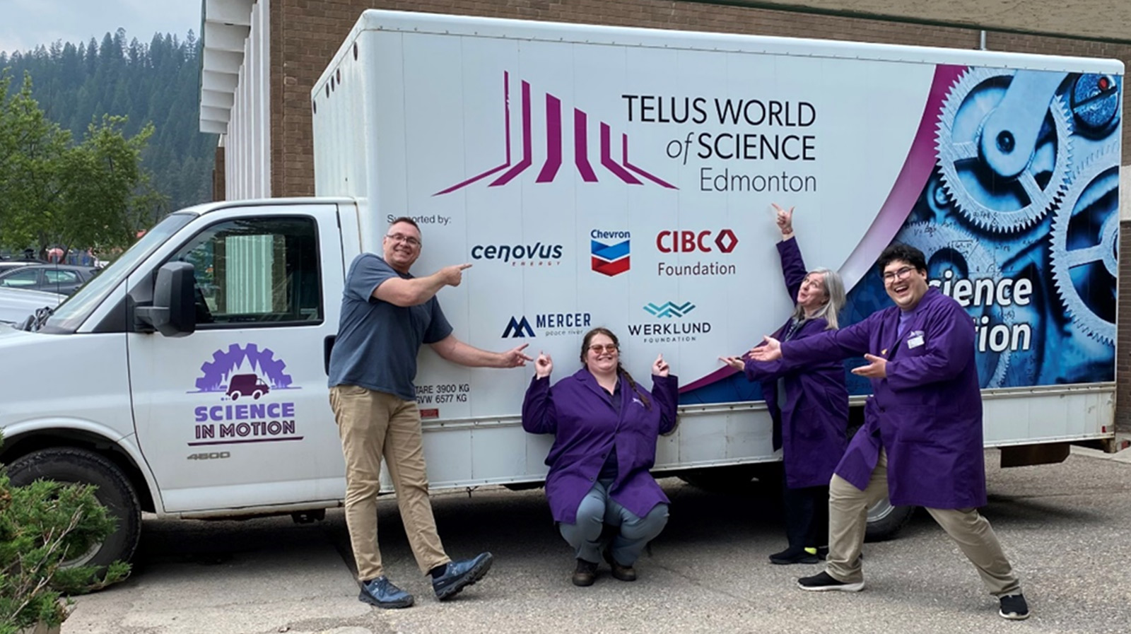 Members of the Science in Motion team pose with the van which bring science to Northern communities
