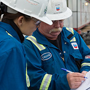 Two Chevron employees reading a safety form