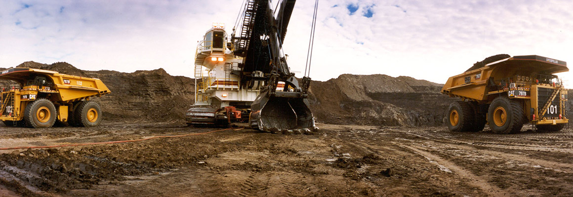 Large trucks and an excavator at the Athabasca oil sands