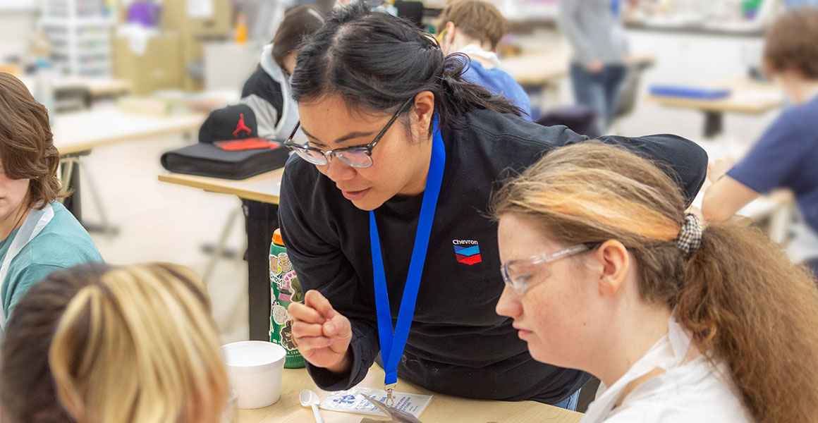 Chevron employee volunteering with students at a school